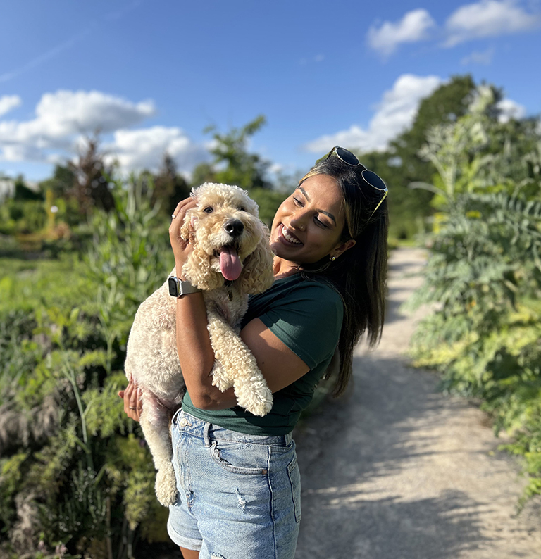 Shivani holding a dog whilst out on a walk