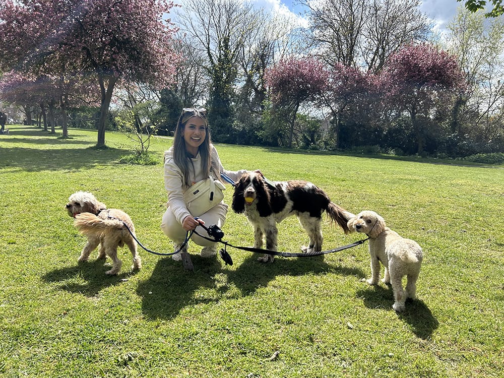 Shivani with a group of dogs on a leash in the park