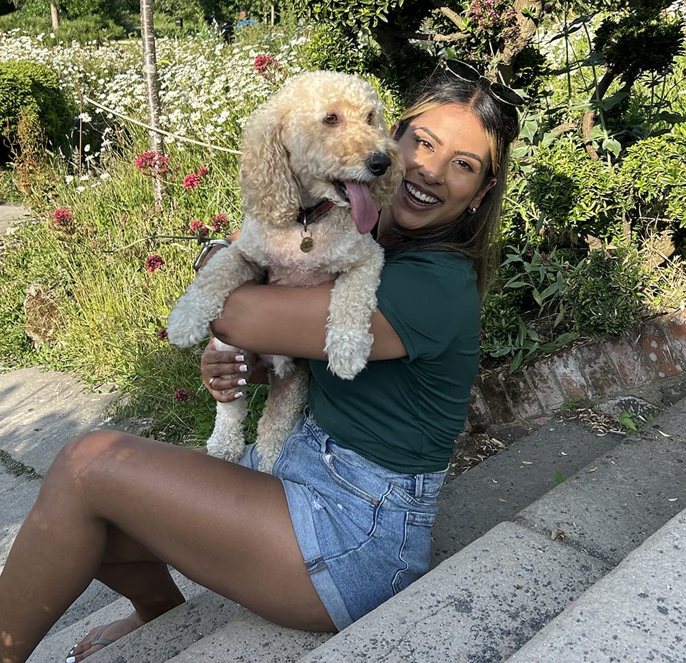 shivani sat on a step cuddling a dog
